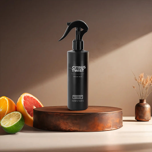 Candl•ogic’s 8 oz. room mist in a black spray bottle labeled ‘No. 029 Citrus Twist’ on a copper tray with citrus and a copper vase in the background.