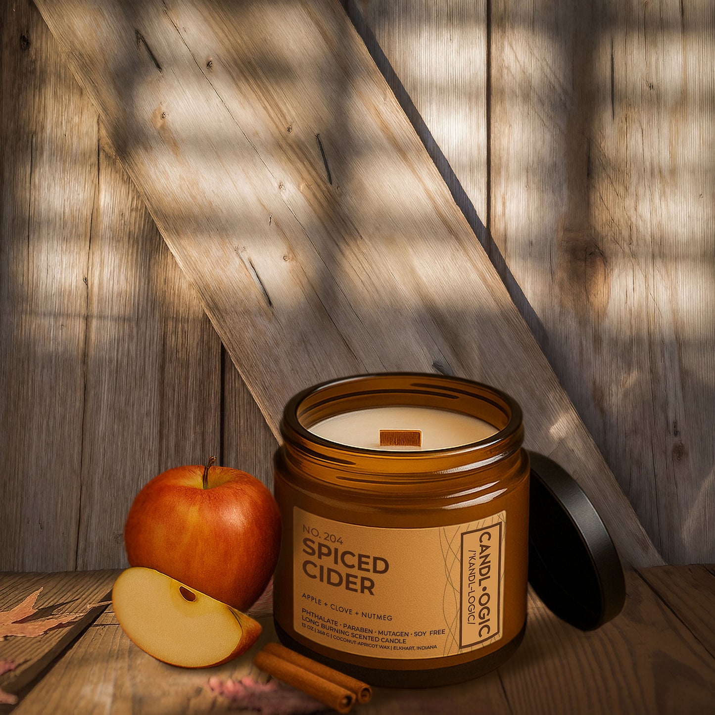Luxury amber jar candle No. 204 Spiced Cider by Candl•ogic, with apple, clove, and nutmeg fragrance, displayed on rustic wooden background with fresh apple slices and cinnamon stick.