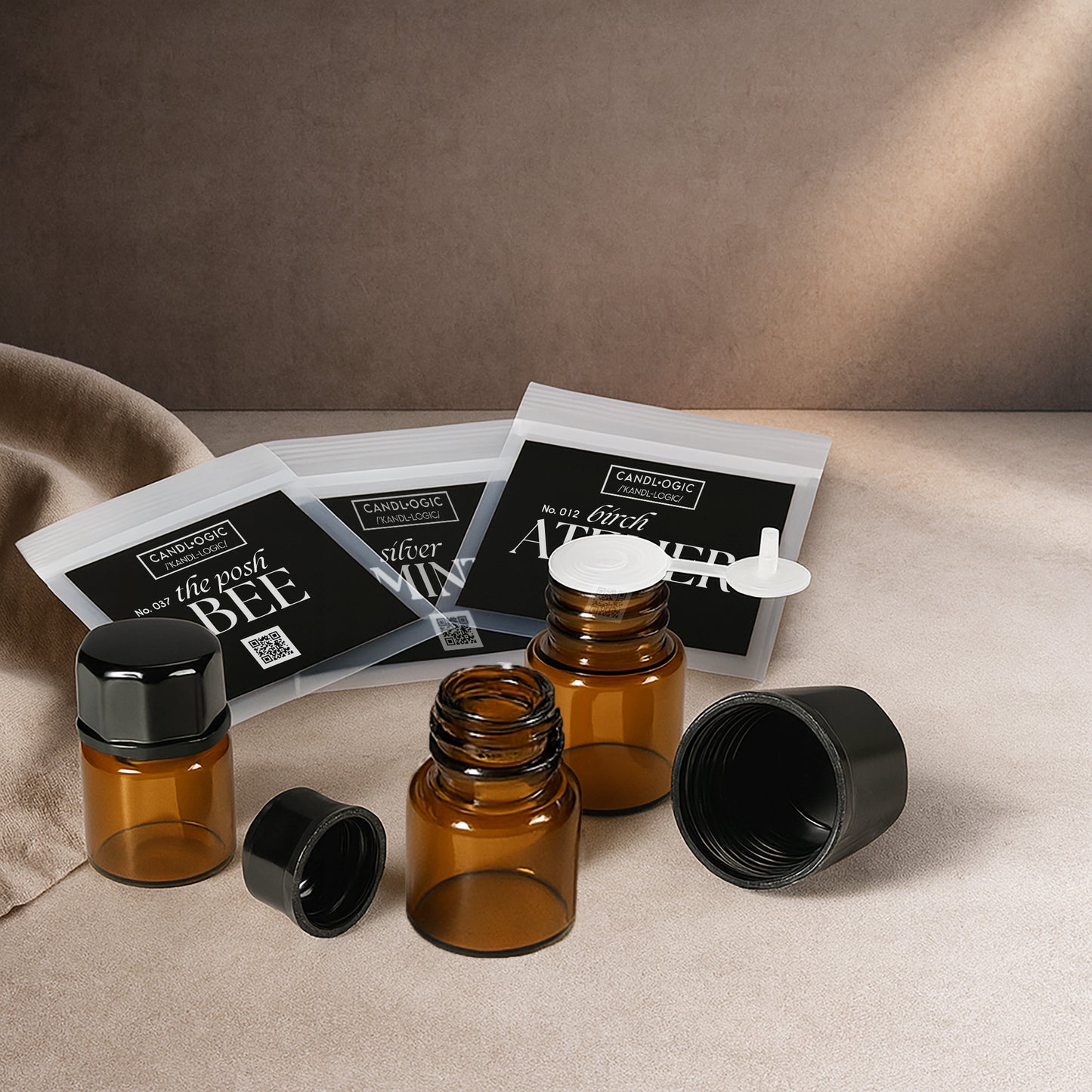 Amber glass bottles with black caps and resealable black-label pouches on a textured surface, minimalist luxury packaging for candles, essential oils, and home fragrance products.