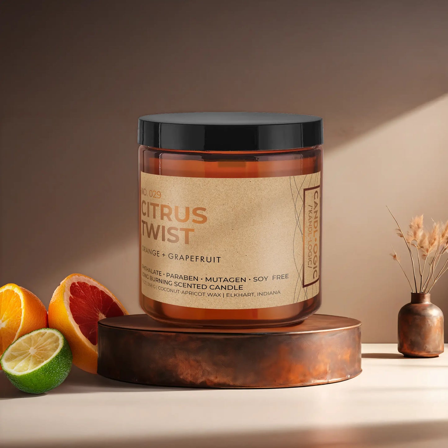 Candl•ogic’s scented candle with a wood wick in an amber glass 16 oz. jar labeled ‘No. 029 Citrus Twist’ on a copper tray with citrus and a copper vase in the background.
