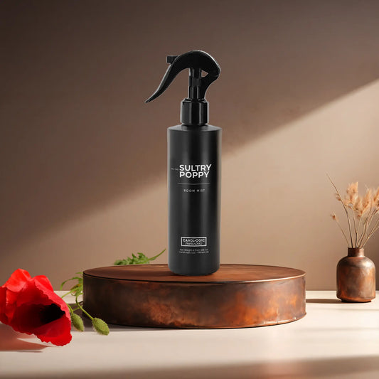 Candl•ogic's 8 oz. room mist in a black spray bottle labeled 'No. 043 Sultry Poppy' on a copper tray with a red poppy flower and a vase in the background.