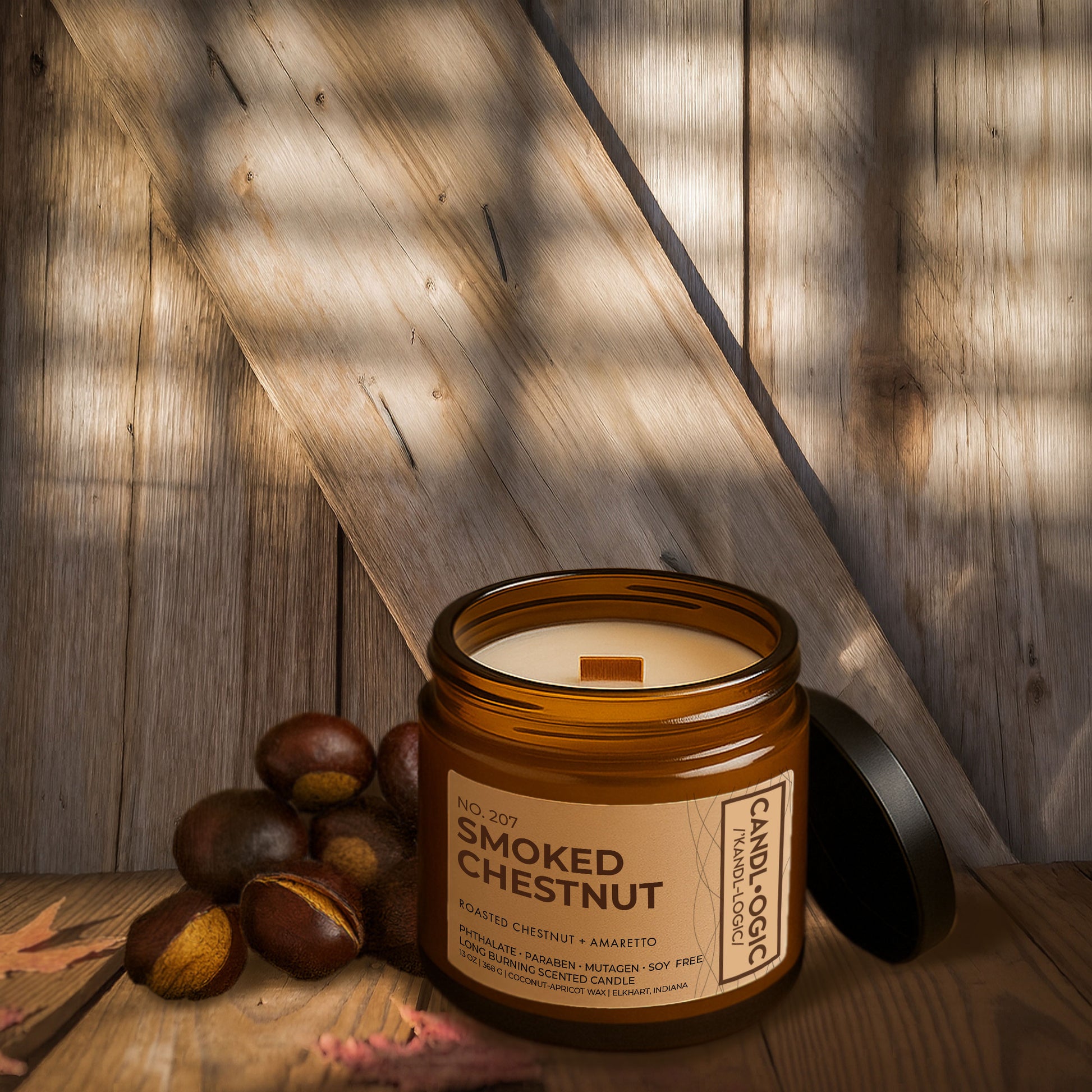 Luxury amber jar candle No. 207 Smoked Chestnut by Candl•ogic, with roasted chestnut and amaretto fragrance, styled on rustic wooden background with whole chestnuts and autumn leaves.